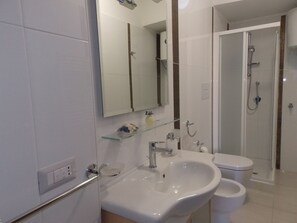 Een douche, een haardroger, een bidet, handdoeken