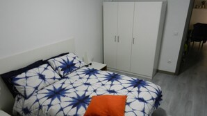 Un dormitorio con cama, armario y mesita de noche.