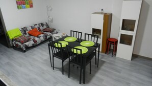 Un espacio habitable compacto con una mesa de comedor, sillas, un sofá y un armario.