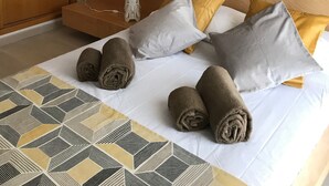 A hotel room with a bed, pillows, and rolled towels. - Apartment T2 Sea View - Varandas do Sol (Portimão)