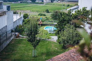 A backyard with a swimming pool, a dog, and a fenced area.