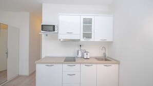 A compact kitchen with white cabinets, a microwave, a kettle, and a toaster. - Cosy studio Stone for 2 with large balcony (Bol)