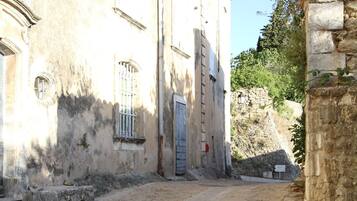 Une rue pavée menant à un bâtiment doté d’une porte et de fenêtres.