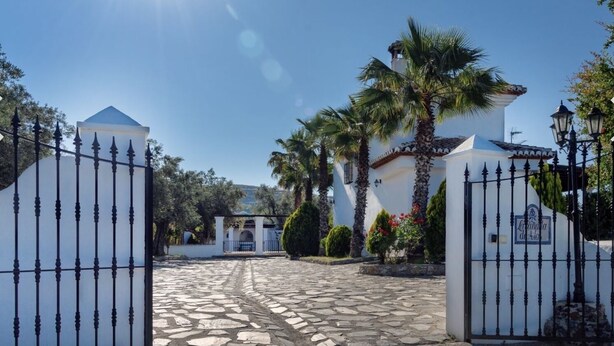 A gated entrance with a cobblestone path leading to a white building with a dome and a bell tower. - Stunning private rural Villa in the Lecrin Valley, Granada with 7mx4m pool (Melegís)