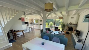 Amplia sala de estar con una mesa de comedor, sofás y una cocina al fondo.
