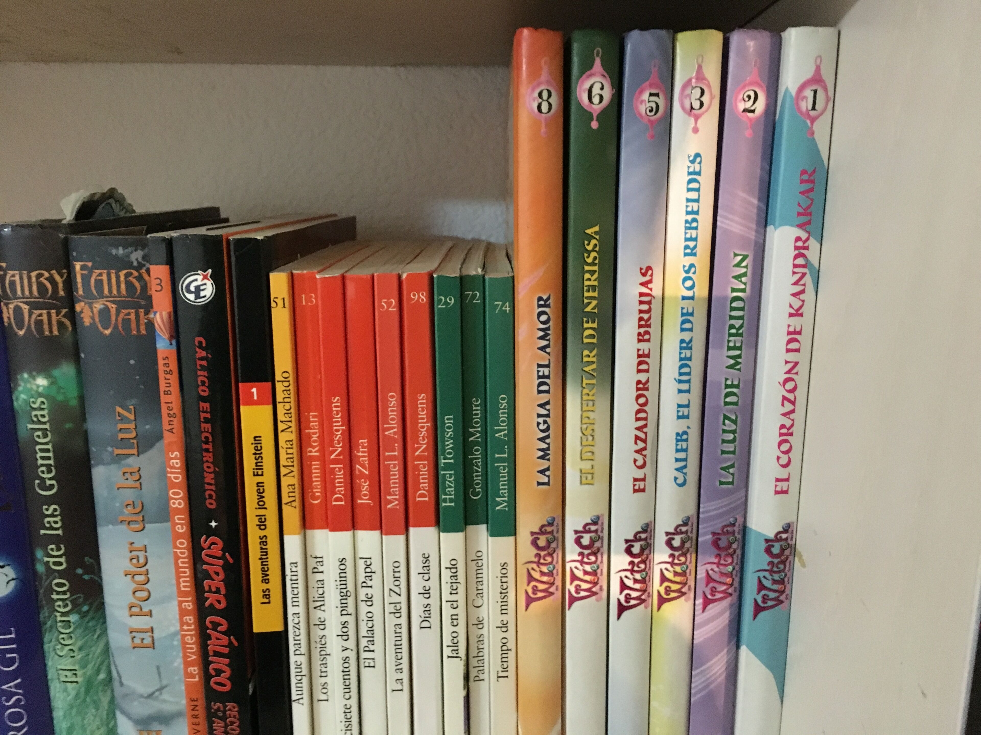 A bookshelf with various books, including titles like 'El Poder de la Luz' and 'El Secreto de las Gemelas'.