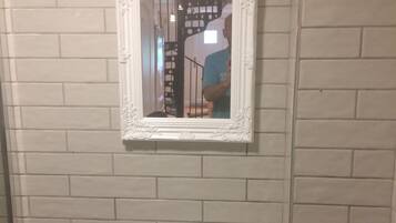 A bathroom with a white sink and a mirror with an ornate frame.