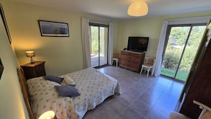 A bedroom with a bed, a television, a desk, and a chair. - Countryside, garden on large plot, with dominant terrace and views (Lasalle)