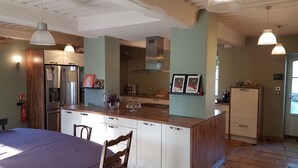 A kitchen with wooden cabinets, a stainless steel refrigerator, and pendant lights. - TOWNHOUSE - LYON COUNTRYSIDE - LARGE GARDEN (Grenay)