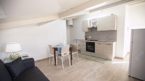 A compact living space with a kitchenette, a dining area, and a sofa. - Villa Barletta apartment mansarded in villa on the first floor number 5 (Marina di Acate)