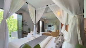 Une chambre avec un grand lit, un canapé et un balcon donnant sur un paysage verdoyant.