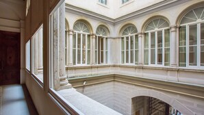 Un patio con ventanas de arco y suelo de piedra.