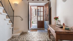 A staircase leading to a stone-floored entrance with a wooden door and window. - Ca S'angel (Soller)