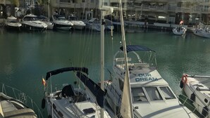 A marina with several sailboats docked, surrounded by buildings with balconies and a clear sky. - Modern apartment in Puerto marina (Benalmádena)