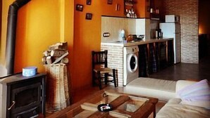 A cozy living room with a fireplace, a sofa, and a coffee table. - Rural house (full rental) Rebollares II for 4-5 people (Piedralaves)