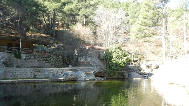 A stone bridge over a calm river, surrounded by trees and a stone wall. - Rural house (full rental) Rebollares II for 4-5 people (Piedralaves)