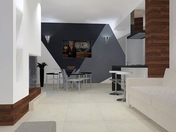 Una sala moderna con una pared de acento oscura, un comedor con mesa y sillas, y un sofá blanco.