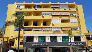 A multi-story yellow building with a storefront labeled "SPRINGFIELD" featuring a large sign and a display window.