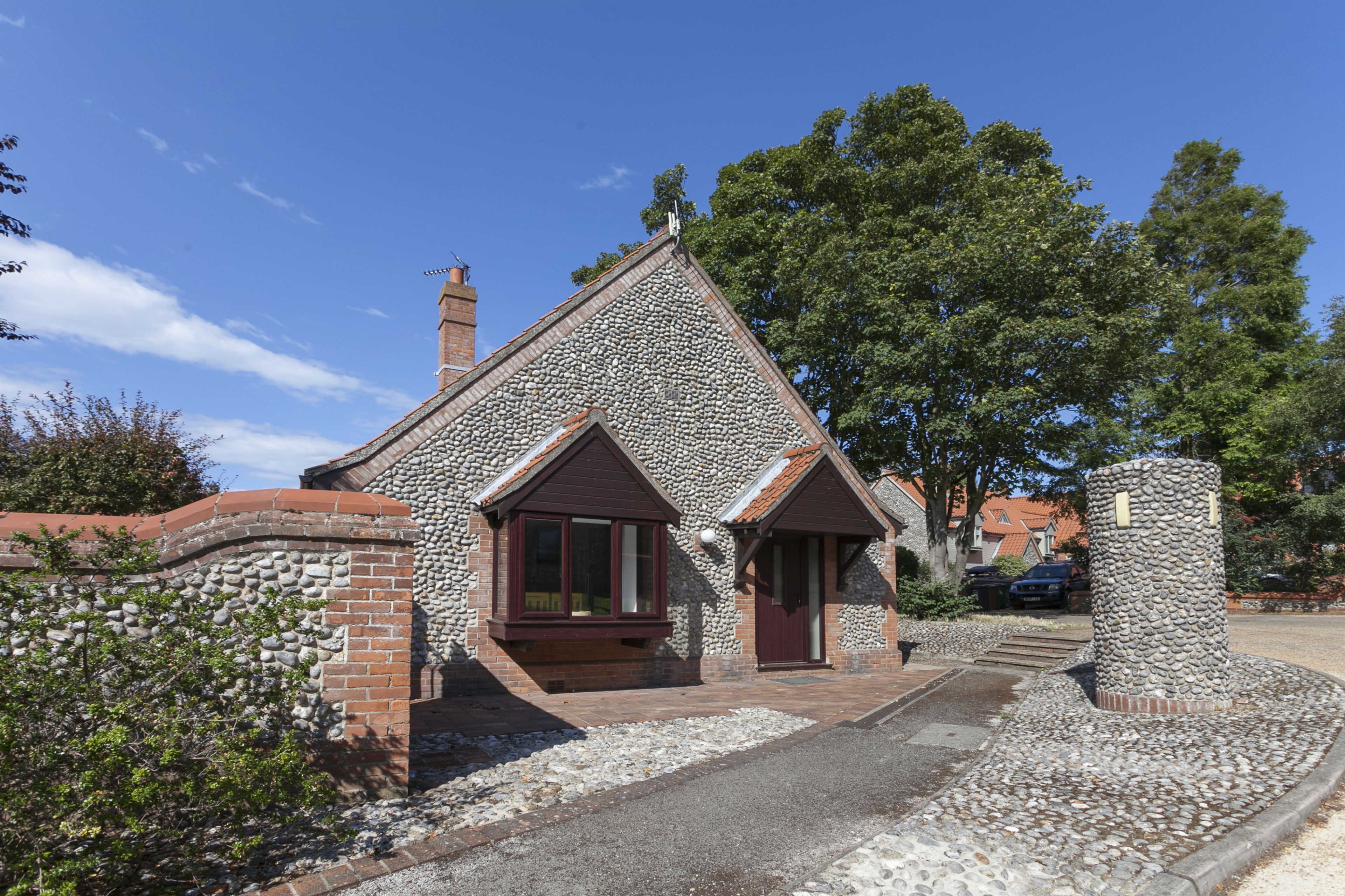 A stone house with a sloped roof, a chimney, and a small porch.