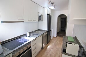 A modern kitchen with white cabinets, a built-in microwave, a stainless steel refrigerator, and a granite countertop. - MARYVILLA0831-Gran Vista-Wifi y Parking Gratis. (Calpe)