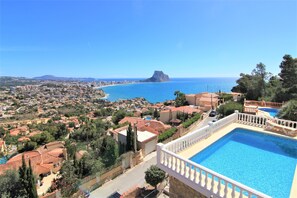 A poolside view overlooking a coastal town with a prominent mountain in the distance. - MARYVILLA0831-Gran Vista-Wifi y Parking Gratis. (Calpe)