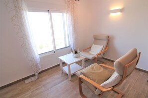 A room with a large window, a white table with a basket of fruit, and two wooden chairs. - MARYVILLA0831-Gran Vista-Wifi y Parking Gratis. (Calpe)