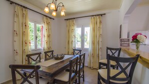 A dining area with a wooden table and chairs, a chandelier, and a sign that says "LIVE LAUGH LOVE". - Perfect for families or couples looking for privacy (Paxos)