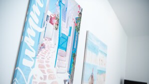 Un mur orné de trois œuvres d’art encadrées représentant des paysages côtiers.