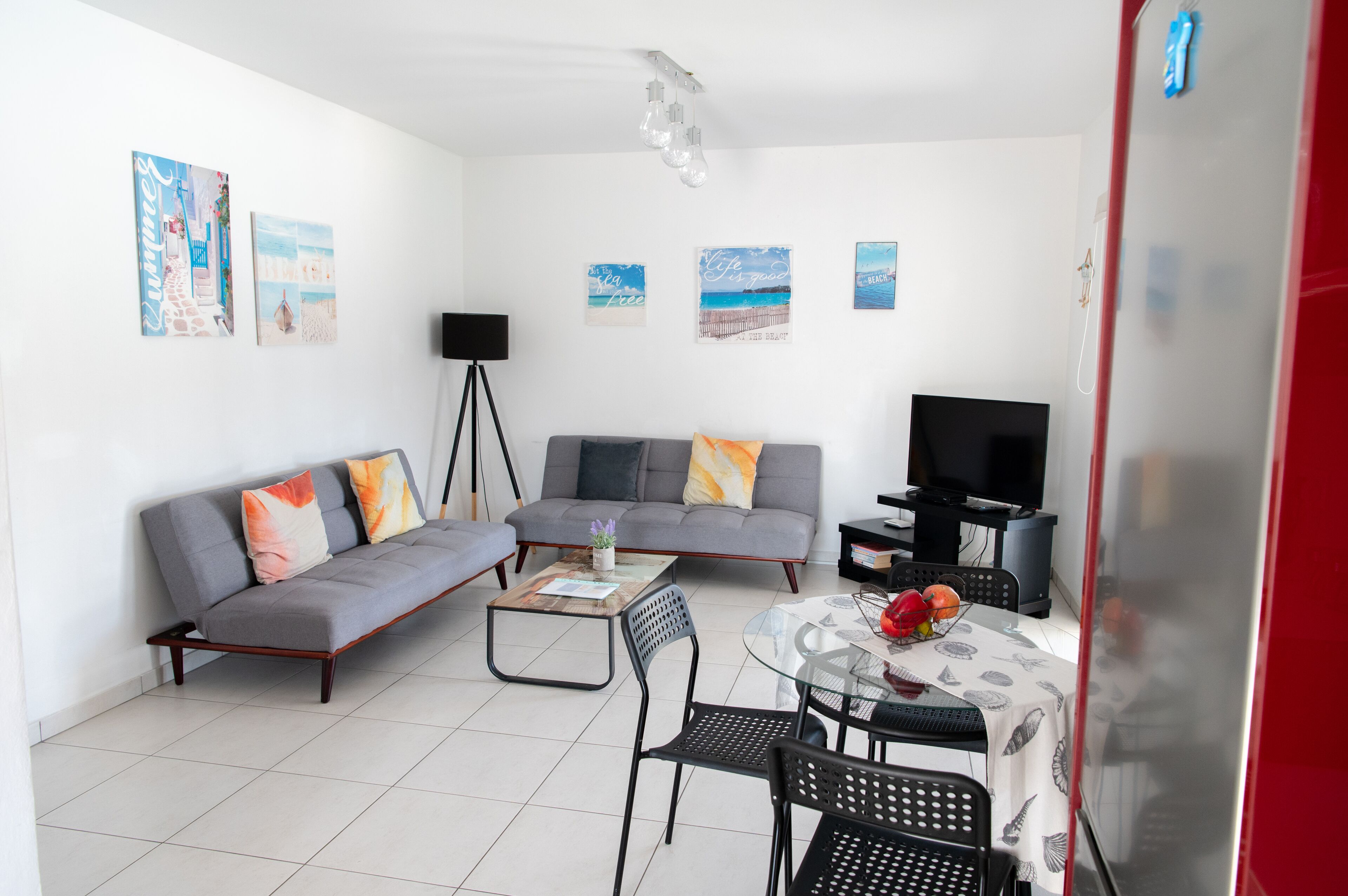 Un salon moderne avec un canapé gris, une table basse et un meuble pour la télévision.