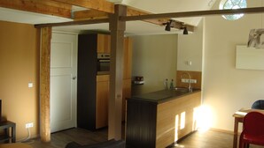 A modern kitchen with wooden beams, a built-in oven, and a window above the sink. - Holiday home / B & B 't Zwaluwnest - peace, space and privacy with its own sauna (Luttenberg)