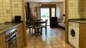Una cocina con comedor, lavadora y chimenea.