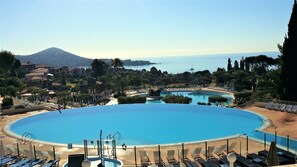 Ein großer Pool mit Blick auf das Meer und die Berge im Hintergrund.