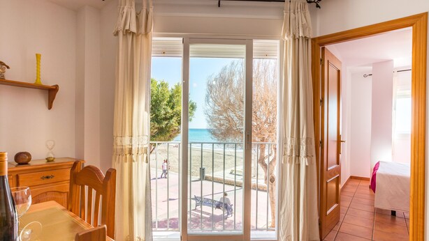 Ein Zimmer mit Balkon, Esstisch und Bett.
