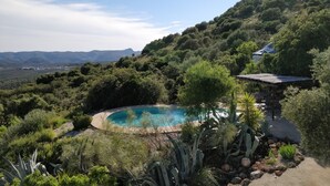 A pool surrounded by lush greenery and hills. - Apartment with big terrace and fantastic views (Iznajar)