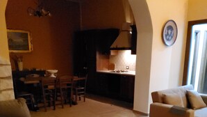 Una sala de estar con sofá, un tapete estampado y un comedor con sillas y mesa.