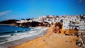 Un pueblo costero con playa de arena y costa rocosa.