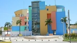 A modern building with a curved facade, large glass windows, and a mix of pastel colors.