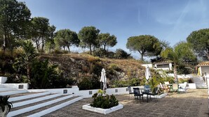 A patio area with outdoor seating, a stone staircase, and a view of a hillside with trees. - Rural house in Sierra de Mijas, private pool, ideal for families and groups. (Mijas)