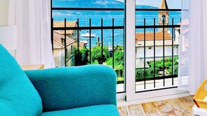 Quarto com vista para o mar e um campanário.