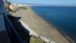 Blick auf die Küste mit Strand, Gebäuden und blauem Himmel.