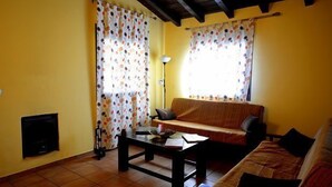 Un salon avec un canapé, une table basse, une lampe et une cheminée.