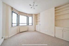 Enjoy a cozy stay in this corner room with shelving, large window, and ceiling fan.