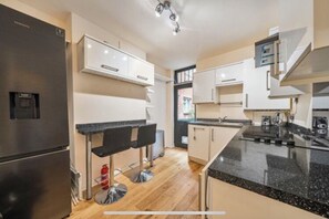 Enjoy cooking in this well-equipped kitchen with a refrigerator, sink, and microwave.