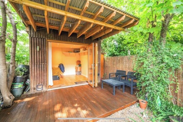 Relax in a serene outdoor space surrounded by lush greenery and a wooden fence, perfect for casual dining or unwinding.