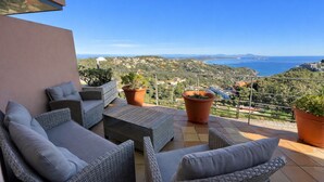 A balcony with wicker furniture, potted plants, and a scenic view of the coastline. - House with spectacular sea views in the historic centre of Begur (Begur)