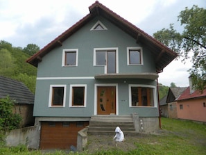 Stunning two-story home with a central entrance, porch, and pitched roof.