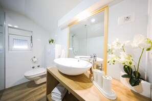 Une salle de bain moderne avec un grand lavabo, des toilettes et une douche.