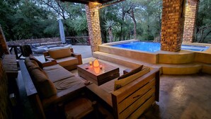 Une terrasse extérieure avec un jacuzzi, des meubles en bois et une piscine.