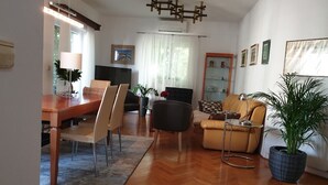 A modern living room with a dining area, wooden flooring, and a large potted plant. - Apartment Keti spacious apartment in the center of Korcula town with sea view (Korčula, Dubrovačko-neretvanska županija)