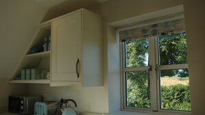 A kitchen with a window, a microwave, a toaster, and a kettle. - The Starting Gate - luxury studio apartment, rural location, 1m from Bruton (Bruton)